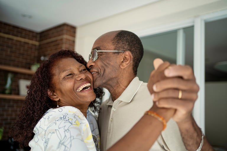 African American senior couple dancing on the balcony